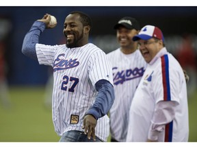 Former Montreal Expos Vladimir Guerrero throws a ceremonial pitch next to Montreal Mayor Denis Coderre and former teammate Orlando Cabrerra during a pre-game ceremony as the Toronto Blue Jays face the Cincinnati Reds in MLB exhibition play on April 3, 2015, in Montreal.