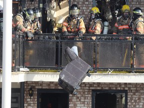 Firefighters clear debris after a fire at the Econo Lodge Motel in Brossard in March.