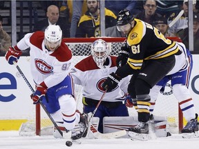 Montreal Canadiens' Jonathan Drouin (92) clears the puck from in front of the net beside Boston Bruins' Rick Nash (61) during the third period of an NHL hockey game in Boston, Saturday, March 3, 2018. The Bruins won 2-1 in overtime.