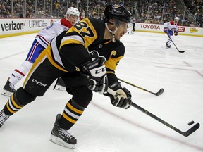 Penguins' Sidney Crosby makes a pass out of the corner with Canadiens' Mike Reilly (28) defending during the second period Wednesday night in Pittsburgh.