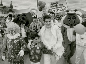 Céline Dion leads a cystic fibrosis walkathon with her eight-year-old niece, Karine Ménard, in 1985.