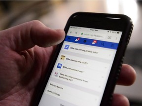 A cellphone user thumbs through the privacy settings on a Facebook account.