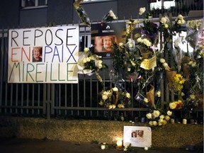 Flowers and placards are displayed outside Mireille Knoll's apartment during a silent march in Paris on Wed., March 28.