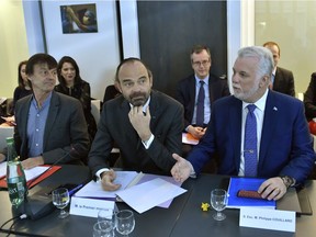 French Prime minister Edouard Philippe, center, Quebec Premier Philippe Couillard, right, and French Minister for the Ecological and Inclusive Transition Nicolas Hulot attend a press conference during a visit at the Pierre et Marie Curie Institute in Paris, France, as part of the international Women's Day, Thursday, March 8, 2018. (Gerard Julien/Pool Photo via AP)