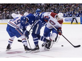 Maple Leafs Tyler Bozak (centre) battles for the puck with Canadiens' Logan Shaw (left) and Nikita Scherbak during first period NHL hockey action in Toronto on Saturday, March 17 , 2018.