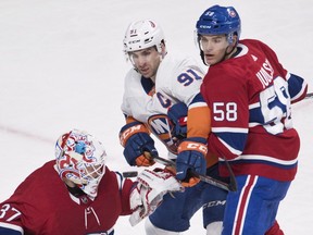 New York Islanders' John Tavares (91) moves in on Montreal Canadiens goaltender Antti Niemi as Canadiens' Noah Juulsen defends in Montreal, on Feb. 28, 2018.