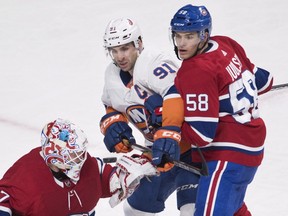 Montreal Canadiens' Noah Juulsen defends against New York Islanders' John Tavares in front of goaltender Antti Niemi in Montreal on Feb. 28, 2018.