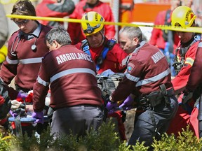 Ambulance technicians and firemen lift one of the victims of a cave-in following a work-related accident in Lachine in 2012.