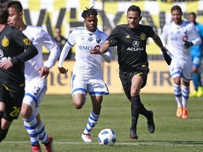 Columbus Crew midfielder Artur (7) locks pace with Montreal Impact forward Raheem Edwards (14) in the second half of a Major League Soccer game in Columbus, Ohio, Saturday, March 10, 2018. (Brooke LaValley /The Columbus Dispatch via AP)