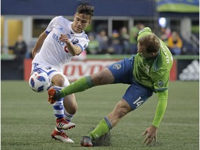 Sounders defender Chad Marshall, right, deflects a pass by Montreal Impact midfielder Ken Krolicki, during the first half of an MLS soccer match on Saturday, March 31, 2018, in Seattle.