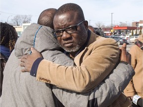 Frederic Kouakou, right, father of missing boy Ariel Jeffrey Kouakou, hugs a supporter Thursday, March 22, 2018 in Montreal. The boy left his home in the city's north end on March 12 to visit a friend's house.