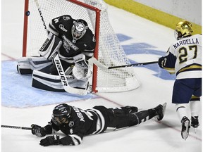 Providence goaltender and Canadiens prospect Hayden Hawkey deflects a shot by Notre Dame's Bobby Nardella (27) as Providence's Ben Mirageas (4) defends during the second period of an NCAA college hockey regional tournament game on Saturday, March 24, 2018, in Bridgeport, Conn.