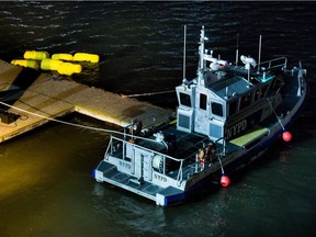 Yellow buoys that a New York police officer said are suspending a helicopter that crashed into the East River float next to a NYPD police boat at a pier in New York on Sunday, March 11, 2018. The helicopter crashed into New York City's East River Sunday night and flipped upside down in the water, killing at least a few people aboard and leaving some others in critical condition, officials said.