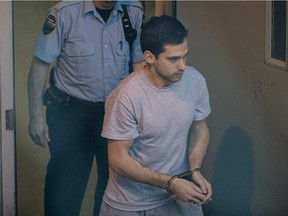 Guillaume Gelinas is escorted into the prisoner's bus as he leaves the Joliette courthouse on Monday, Feb. 17, 2014.