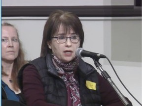 Ginette Chartre speaks while wearing a yellow badge during Outremont's borough council meeting Monday night to protest the use of school buses by the community's Hasidic Jews.