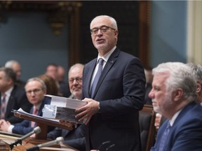 Quebec Finance Minister Carlos Leitão tables his budget, Tuesday, March 27, 2018 at the National Assembly in Quebec City. Quebec Premier Philippe Couillard, right, looks on.