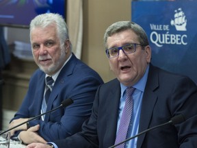 Quebec City Mayor Regis Labeaume, right, and Quebec Premier Philippe Couillard watch a video presentation at a news conference to announce a tramway for Quebec City Friday, March 16, 2018 at Quebec City Hall.