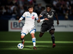 Montreal Impact's Michael Petrasso and Vancouver Whitecaps' Alphonso Davies vie for the ball during the first half of an MLS soccer game in Vancouver, B.C., on Sunday March 4, 2018.