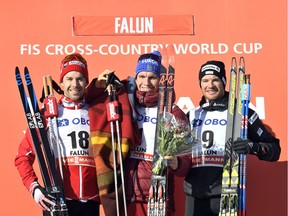 Winner Russia's Alexander Bolshunov, centre, celebrates on the podium with second placed Alex Harvey of Canada, left, and third placed Dario Cologna of Switzerland after the Men's 15 km Pursuit Free race at the FIS Cross-Country World Cup on Sunday March 18, 2018 in Falun Sweden.