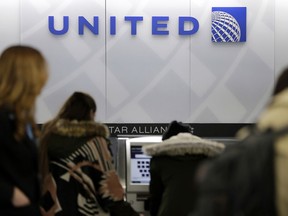 People stand in line at a United Airlines counter at LaGuardia Airport in New York. A dog died on a United Airlines plane after a flight attendant ordered its owner to put the animal in the plane's overhead bin. United said Tuesday, March 13, 2018, that it took full responsibility for the incident on the Monday night flight from Houston to New York.