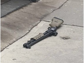 A shotgun lies on the sidewalk outside the Giorgio Gruppo Roma boutique on Peel St. in Montreal after a man was shot once inside the boutique on March 12, 2018.