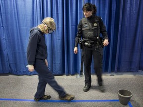 A student tries to "walk the line" with goggles that simulate drunken vision, as a Station 5 constable watches in March 2013. This week, Montreal police Station 5 is hosting its annual Substance Abuse Prevention Days for Grade 6 students attending schools in Dorval and Pointe-Claire.