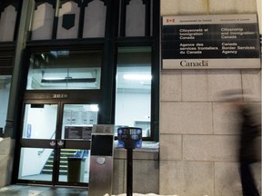 A pedestrian walks past the Citizenship and Immigration Canada and Canada Border Services Agency offices in Montreal, in 2016.