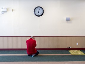 A man is overcome with grief while praying at the Centre Culturel Islamique de Québec in Quebec City, Wedesday February 1, 2017, after some people were allowed inside for the first time since a mass shooting at the centre, January 29, in which six people were killed.