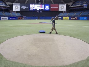 MONTREAL, QUE.: MARCH 31, 2016 -- Ben Jamieson,walks past pitching mound, at Montreal Olympic stadium on Thursday March 31, 2016. Montreal is hosting pre-season games of Major League Baseball on Friday and Saturday. The Toronto Blue Jays will meet the Boston Red Sox.