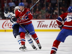 Montreal Canadiens left wing Kerby Rychel knocks Winnipeg Jets defenceman Sami Niku to the ice during NHL action in Montreal on Tuesday April 3, 2018.