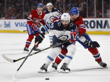Montreal Canadiens defenceman Brett Lernout ties up Winnipeg Jets centre Mathieu Perreault during NHL action in Montreal on Tuesday April 3, 2018.