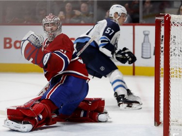Montreal Canadiens goaltender Carey Price looks back as Winnipeg Jets defenceman Tyler Myers looks into the net after Winnipeg Jets Kyle Connor scored the winning goal in overtime during NHL action in Montreal on Tuesday April 3, 2018.