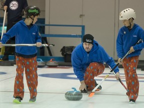 Nicolas Janidlo left, and Zachary Janidlo right watch as their father/coach Steve Janidlo slides his stone down the ice during the 20th annual Kurling for Kids Tournament at the Pointe Claire Curling Club on Saturday.