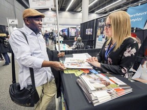 Ali Diaoune, originally from Guinea, speaks with L'Orienthèque's Jessica Campeau during a job fair held at the Palais des congrès on Wednesday.