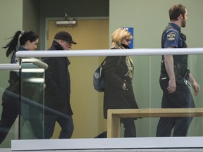 Manon Marchand and Raymond Bissonnette, left, the parents of Alexandre Bissonnette, leave the courtroom under escort after their son Alexandre Bissonnette pleaded guilty for the 2017 mosque shooting, Wednesday, March 28, 2018 at the hall of justice in Quebec City.