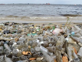 Plastic bottles and other waste lie on the sand after being washed ashore near the port of Abidjan, Côte d’Ivoire, on August 5, 2015.