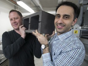 Mehrdad Mahoutian, right, and Chris Stern of Carbicrete display a concrete block they developed using steel slag, at their McGill lab on April 18, 2018.