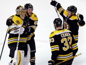 Boston Bruins goaltender Tuukka Rask, left, is congratulated by teammates after the Bruins defeated the Toronto Maple Leafs 7-4 during Game 7 of an NHL hockey first-round playoff series in Boston, Wednesday, April 25, 2018. From left are Rask, David Pastrnak, Zdeno Chara and Matt Grzelcyk.