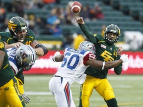 Edmonton's Mike Reilly (13) is tackled by Montreal's Hénoc Muamba during the first half between the Edmonton Eskimos and the Montreal Alouettes at Commonwealth Stadium in Edmonton on Nov. 1, 2015.