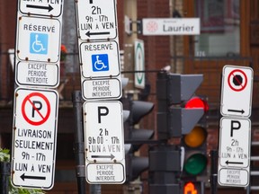 Parking restriction signs and signs for vignette and handicap permits on the corner of de Gaspé and Laurier Sts. in the neighbourhood of Plateau-Mont-Royal in Montreal on Tuesday, August 13, 2013.