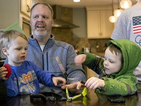 In this Friday, Feb. 16, 2018 photo, Francisco, 2, and Tucker, 4, play as their dad, Jay, is interviewed in their home in Grand Rapids, Mich. The Schwandt family has 13 sons and have welcomed a 14th into the family. The couple's latest addition was born Wednesday evening, April 18 five days before the baby's expected due date.