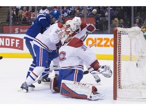 Canadiens goaltender Carey Price makes a stop as Canadiens defenceman Karl Alzner battles with Maple Leafs' James van Riemsdyk (left) during second period NHL hockey action in Toronto, on Saturday, April 7, 2018.