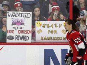 Fans hold up signs in support of Ottawa Senators captain Erik Karlsson (65) during the warm-up before NHL hockey action against the Winnipeg Jets at the Canadian Tire Centre in Ottawa on Monday, April 2, 2017.