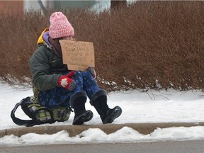 A homeless woman looks for handouts at the side of the road in front of the Valu-mart in Wortley Village in London, Ontario on Tuesday February 7, 2017.