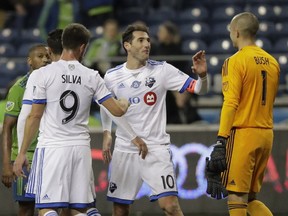 "I felt something in my quadriceps and I couldn't play against New England," says Montreal Impact captain Ignacio Piatti, greeting goalkeeper Evan Bush, right, following a match against the Seattle Sounders on March 31, 2018, in Seattle.