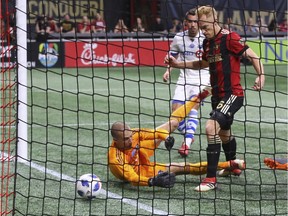 Atlanta United FC midfielder Jeff Larentowicz gets the ball past Impact goalkeeper Evan Bush, but the play was ruled offside during MLS action at Mercedes-Benz Stadium in Atlanta on April 28, 2018.