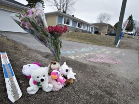 Flowers, plush toys and a written message are set on the driveway of the house where the body of two-year-old Rosalie Gagnon was found in a garbage pail, Thursday, April 19, 2018 in Quebec City. A Quebec City mother has been arrested in the slaying of her two-year-old daughter and is expected to be arraigned later today.