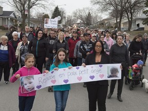 Amelie Tremblay, right, leads a silent march to commemorate the tragic death of two-year-old Rosalie Gagnon, Tuesday, April 24, 2018 in Quebec City. Over 500 people showed up to the site where Rosalie was found in a garbage can.