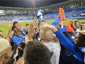 Montreal Impact's Patrcie Bernier is lifted up by teammates following his final MLS soccer game, against the New England Revolution in Montreal on Oct. 22, 2017.