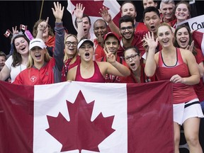 Members of team Canada celebrate after defeating Ukraine in the Fed Cup tennis tournament in Montreal, Sunday, April 22, 2018.